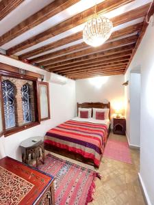 a bedroom with a bed and a chandelier at Dar Sababa in Chefchaouene