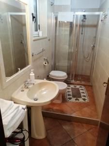 uma casa de banho com um lavatório, um chuveiro e um WC. em Casa Chiara em Scilla
