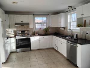 a kitchen with white cabinets and black counter tops at Bluenose Bed and Breakfast in Halifax