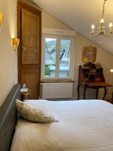 a bedroom with a bed and a window and a piano at DOMAINE du MOULIN in Saint-Avold