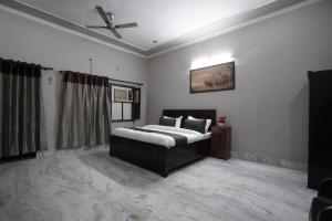 a bedroom with a bed and a ceiling fan at Sun flower Residency in Greater Noida