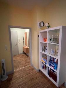 a room with a white book shelf and a hallway at 4 Ferienwohnung - Ferien Mittendrin in Schwerin