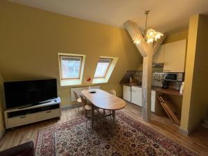 a living room with a wooden table and a kitchen at Ferien Mittendrin - Ferienwohnung 4 in Schwerin