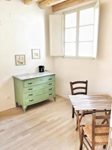 une salle à manger avec une commode verte et une table dans l'établissement Casa Barteèi, à Monte Isola