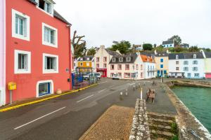 a city street with colorful buildings next to the water at Le Sauzon - Vue sur le port - Proche de la plage in Sauzon