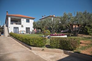 a house with a yard with bushes and flowers at ELENA'S VILLA WITH VIEW in Néa Tríglia