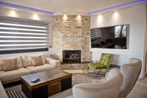 a living room with a couch and a fireplace at ELENA'S VILLA WITH VIEW in Néa Tríglia
