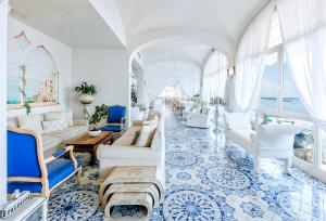 a living room with white furniture and blue tiles at Miramare E Castello in Ischia