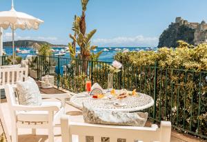 a table and chairs with a view of the ocean at Miramare E Castello in Ischia