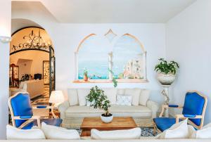 a living room with a couch and two blue chairs at Miramare E Castello in Ischia