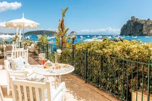 a table and chairs with a view of the water at Miramare E Castello in Ischia