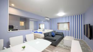 uma sala de estar com uma parede listrada em azul e branco em Crice Hotel Ishigakijima em Ishigaki