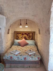 ein Schlafzimmer mit einem Bett mit zwei Büchern darauf in der Unterkunft Conibianchi Trulli&YurtArt House in Ceglie Messapica