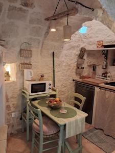 eine Küche mit einem Tisch und einer Obstschale darauf in der Unterkunft Conibianchi Trulli&YurtArt House in Ceglie Messapica