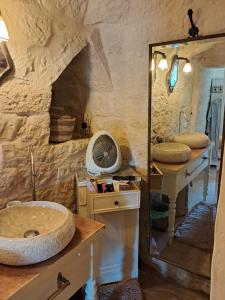 ein Bad mit einem Waschbecken, einem Spiegel und einem Ventilator in der Unterkunft Conibianchi Trulli&YurtArt House in Ceglie Messapica