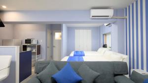 um quarto com uma cama azul e branca e um sofá em Crice Hotel Ishigakijima em Ishigaki Island
