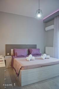 a bedroom with a large bed with pink and purple pillows at ELENA'S VILLA WITH VIEW in Néa Tríglia