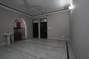 an empty room with two black doors and a sink at Sun flower Residency in Greater Noida