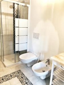 La salle de bains est pourvue de toilettes, d'un lavabo et d'une douche. dans l'établissement Casa Barteèi, à Monte Isola