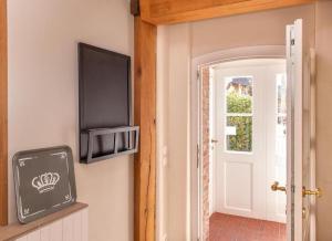 a flat screen tv on a wall next to a door at Welkimmen in Nebel