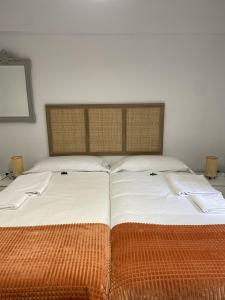 1 cama grande con sábanas blancas y manta naranja en Apartamento en Getxo. Cercano al puerto viejo, en Getxo