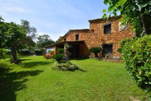 una vieja casa de ladrillo con un patio con césped en Club Villamar - Massia Lucrecia, en Maçanet de la Selva