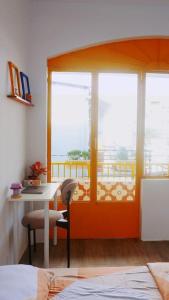 a room with a bed and a table and a window at Joie Home in Nha Trang