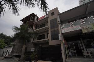 a building with a palm tree in front of it at Sun flower Residency in Greater Noida