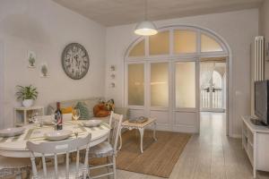 a dining room with a table and a clock on the wall at "Casa Tarconte" nel cuore di Cortona in Cortona