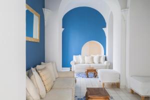 a living room with blue walls and white furniture at Miramare E Castello in Ischia