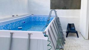 uma piscina com uma cadeira e uma banheira em Hopstays - Almada Getaway em Almada