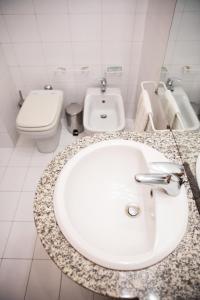 uma casa de banho com um lavatório branco e um WC. em Appartamento milano, Bruna House em Milão