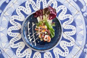 a blue plate with a salad on a table at Miramare E Castello in Ischia