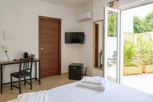 a bedroom with a bed and a desk and a television at EG Apartments - Forio d'Ischia in Forio d'Ischia