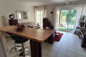 una cocina con una gran mesa de madera en la sala de estar. en Les Jardins - 4 pers - 10 min Plage - Mandelieu, en Mandelieu-la-Napoule