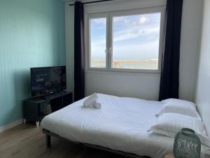 1 dormitorio con 1 cama, ventana y TV en La Vague, en Calais