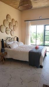 - une chambre avec un lit et une grande fenêtre dans l'établissement Kichuguu farmstay cottage, à Mtito Andei