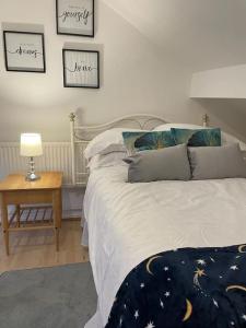 a bedroom with a bed and a table with a lamp at 3 Bedroom Home In Stoke in Stoke on Trent