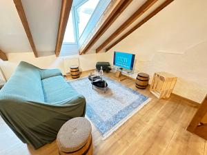 ein Wohnzimmer mit einem Sofa und einem TV in der Unterkunft Chez Alain Prévu - Boutique Hotel by Stay Swiss in Pruntrut
