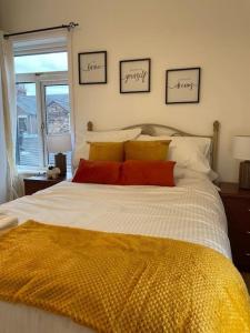 Schlafzimmer mit einem Bett mit gelben und roten Kissen in der Unterkunft 3 Bedroom Home In Stoke in Stoke on Trent