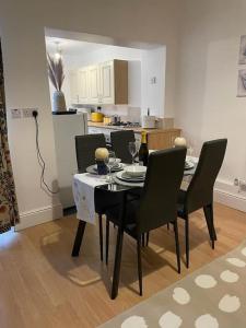 a dining room table with chairs and a kitchen at 3 Bedroom Home In Stoke in Stoke on Trent