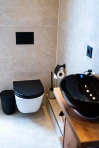 baño con aseo negro y lavamanos en Angelinas Service Apartment 1, en Oberhausen