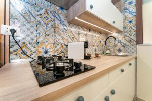 uma cozinha com um fogão e uma parede de azulejos em Catania Easy Center Home em Catânia