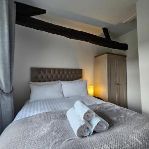 una camera da letto con un letto e asciugamani di Bobtail Cottage by Woodland Park a Staveley