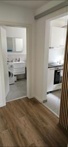 カルフにあるFerienwohnung Auszeitの白い壁とウッドフロアのキッチン