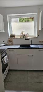 cocina con fregadero y ventana en Ferienwohnung Auszeit en Calw