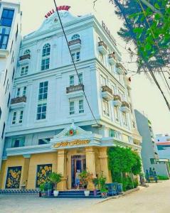 un gran edificio blanco con una tienda delante en FULL HOUSE Hotel, en Ðong Thon