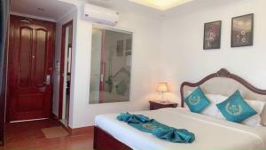 1 dormitorio con cama con almohadas azules y espejo en FULL HOUSE Hotel, en Ðong Thon