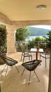 un patio con 2 sillas y una mesa con vistas en Seafront apartments en Bigovo