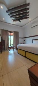 - une chambre avec un grand lit, un bureau et une table dans l'établissement JEEVAN HOMESTAY kovalam, à Kovalam